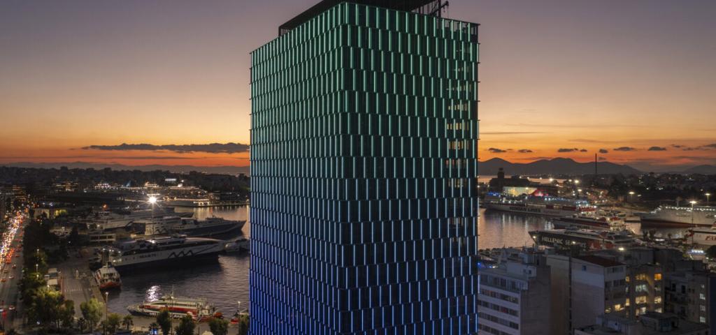 Η Αττικές Εκδόσεις "ντύνει" τις προσόψεις στον Πύργο Πειραιά  Η Αττικές Εκδόσεις "ντύνει" τις προσόψεις στον Πύργο Πειραιά